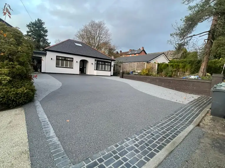 Wide silver resin bound driveway with a charcoal block border and matching path, built on a full-depth base by S P Groundworks & Driveways